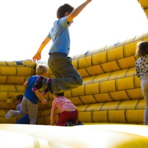 kids-enjoying-a-fun-time-bouncing-in-a-vibrant-inflatable-castle-outdoors
